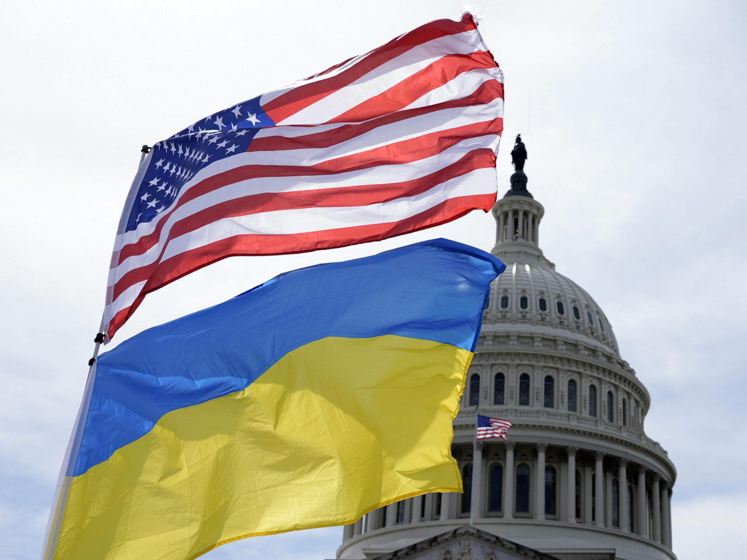 The American and Ukrainian flags wave in the wind outside of the Capitol. The Senate is moving ahead with $95 billion in war aid to Ukraine, Israel and Taiwan.