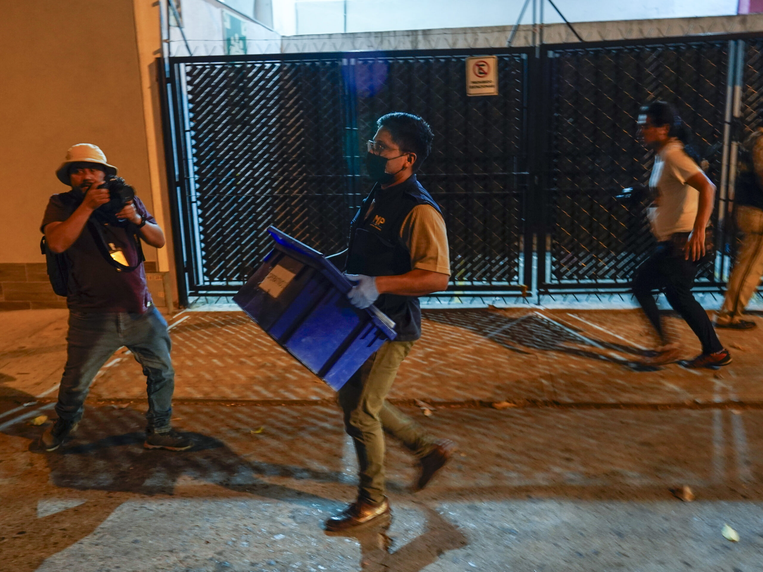An agent from the attorney general's office carries evidence collected at Save the Children's headquarters during a raid in Guatemala City on Thursday, April 25, 2024.