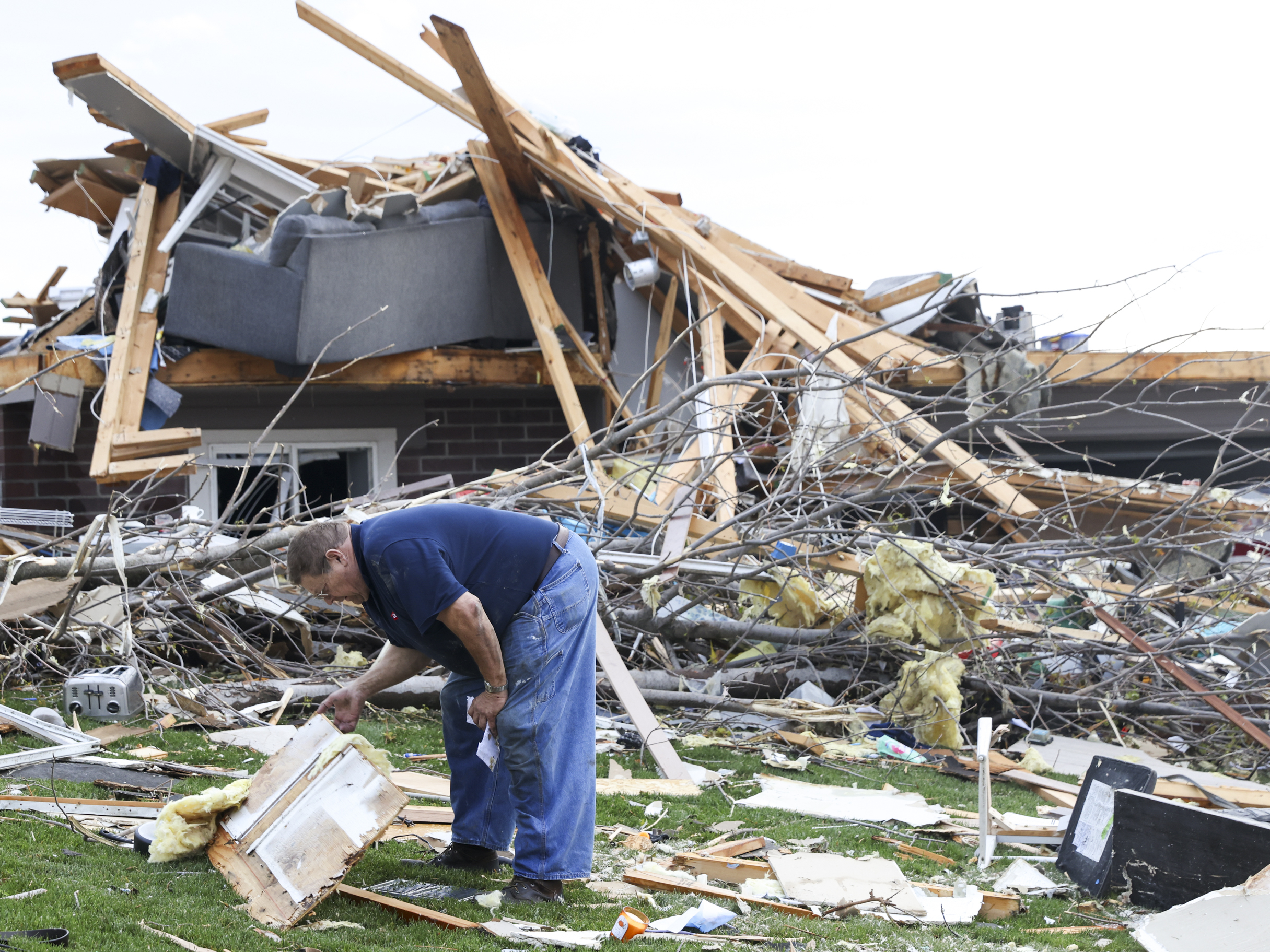 Terry Kicking sifts through the damage after a tornado leveled his home on Friday in Omaha, Neb.