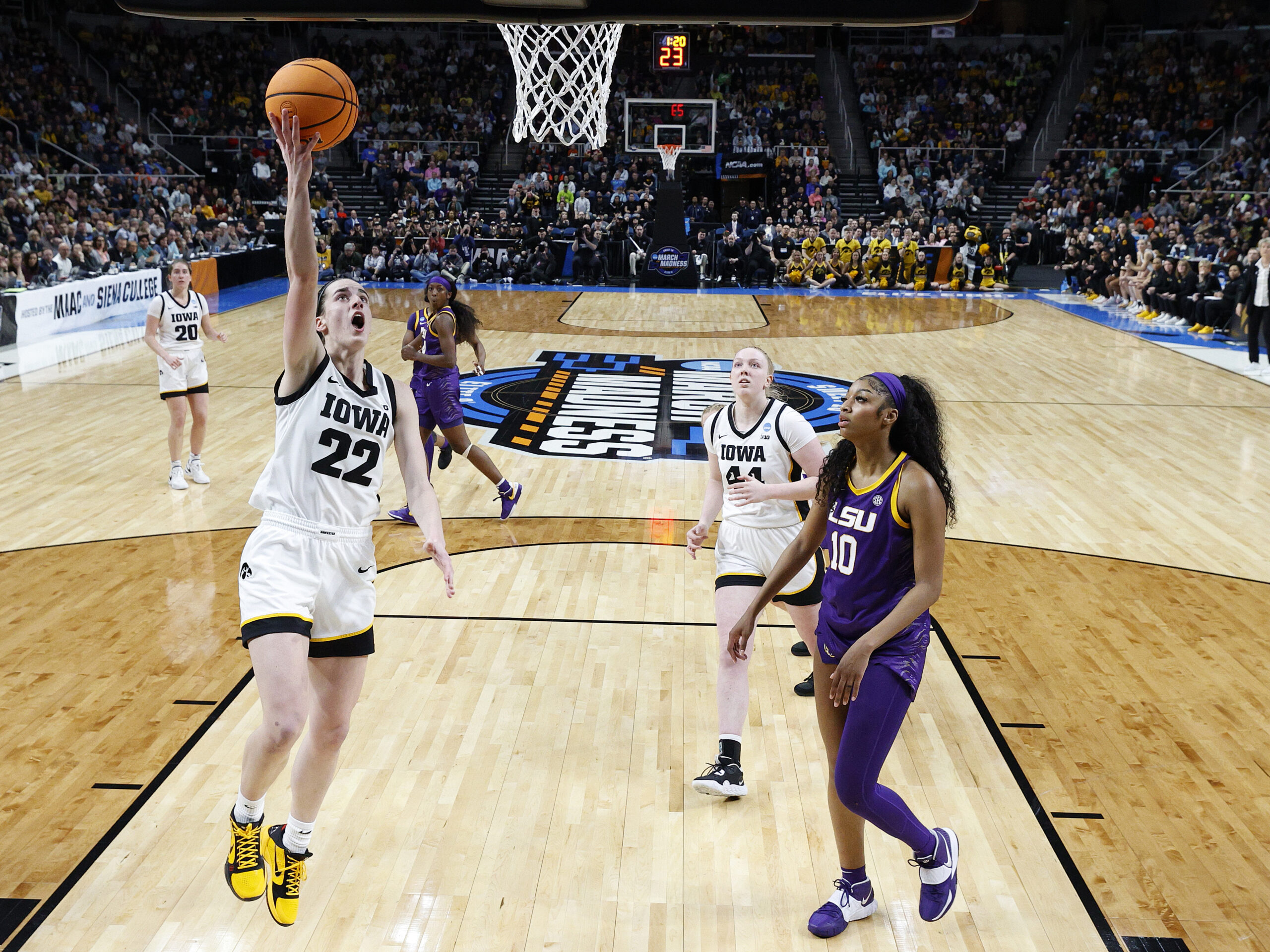 Caitlin Clark of the Iowa Hawkeyes shoots the ball over Angel Reese of the LSU Tigers during the first half in the Elite 8 round of the NCAA Women's Basketball Tournament at MVP Arena on April 1, 2024 in Albany, New York.