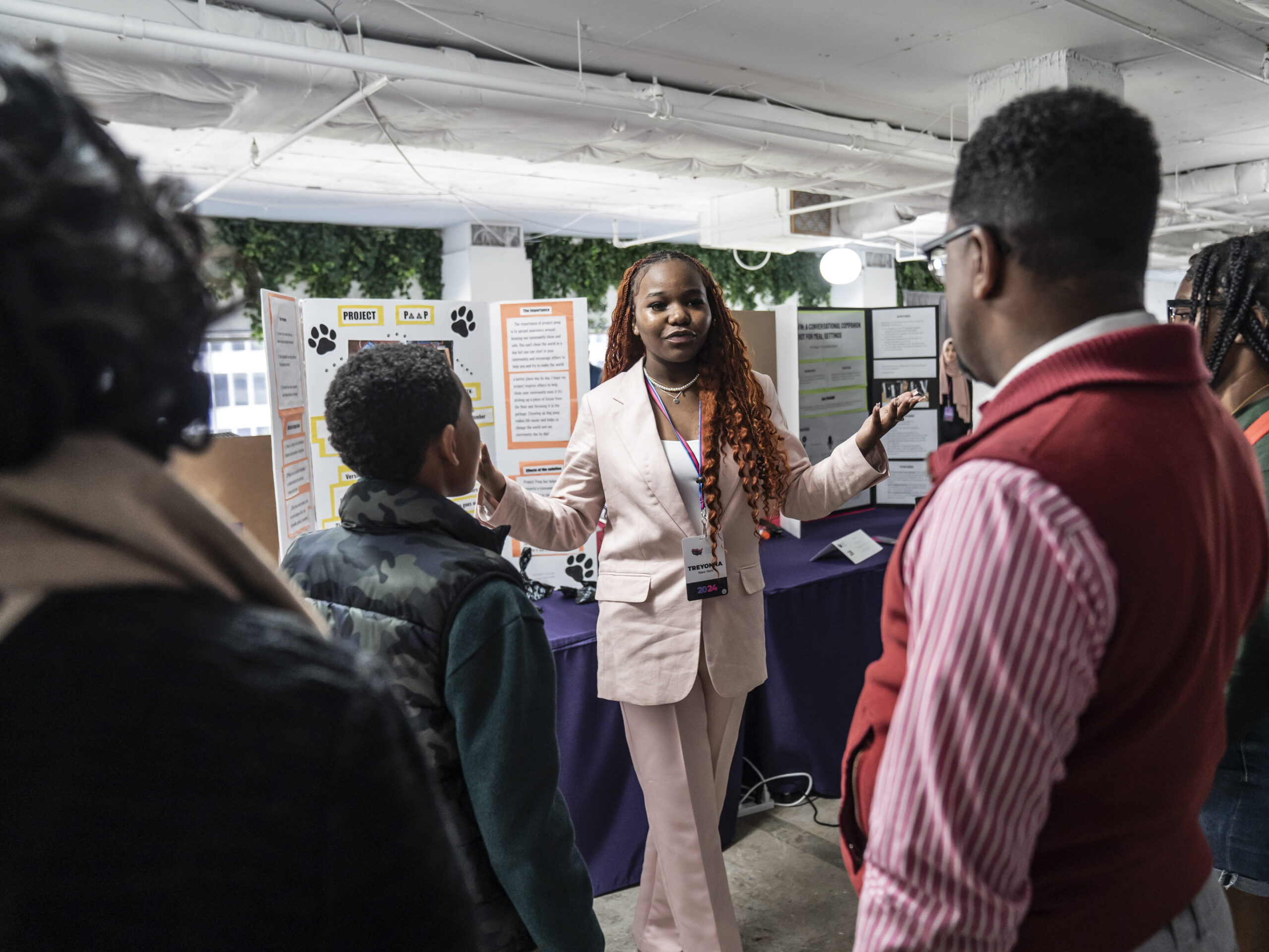 At the National STEM Festival, 12th-grader Treyonna Sullivan talks with visitors about her "Project Poop," created to encourage pet owners in her community to dispose of their pet's waste.