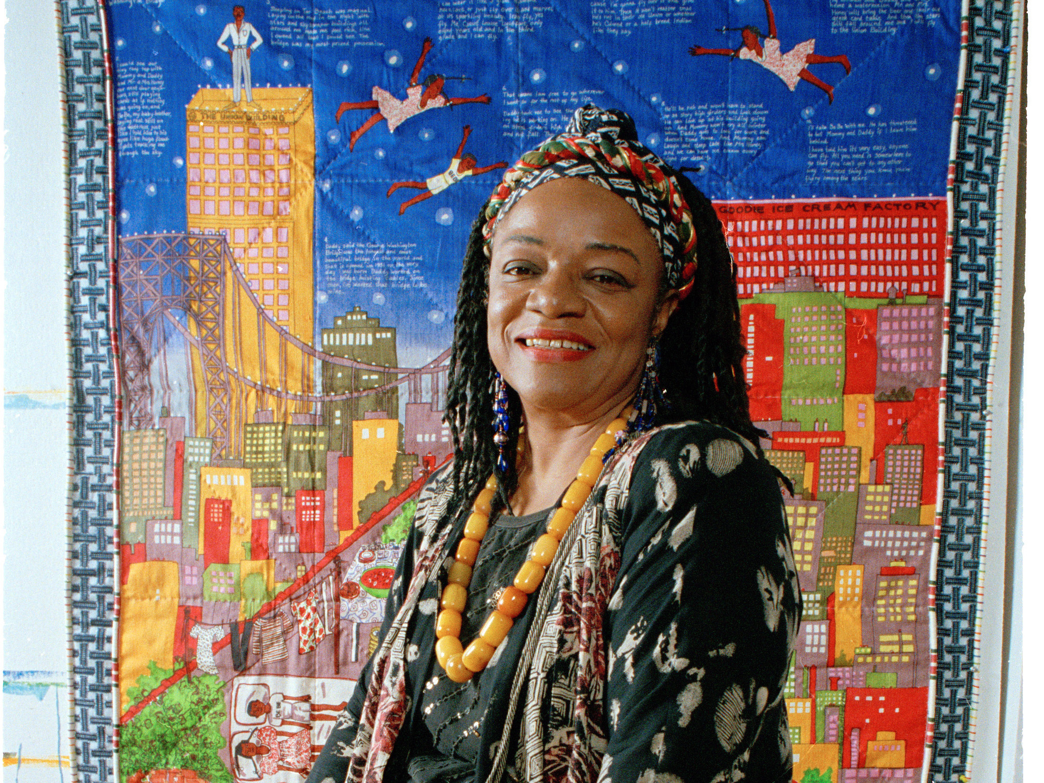 Artist Faith Ringgold sits before her quilt "Tar Beach" in 1993. The artwork also inspired a children's book of the same name.