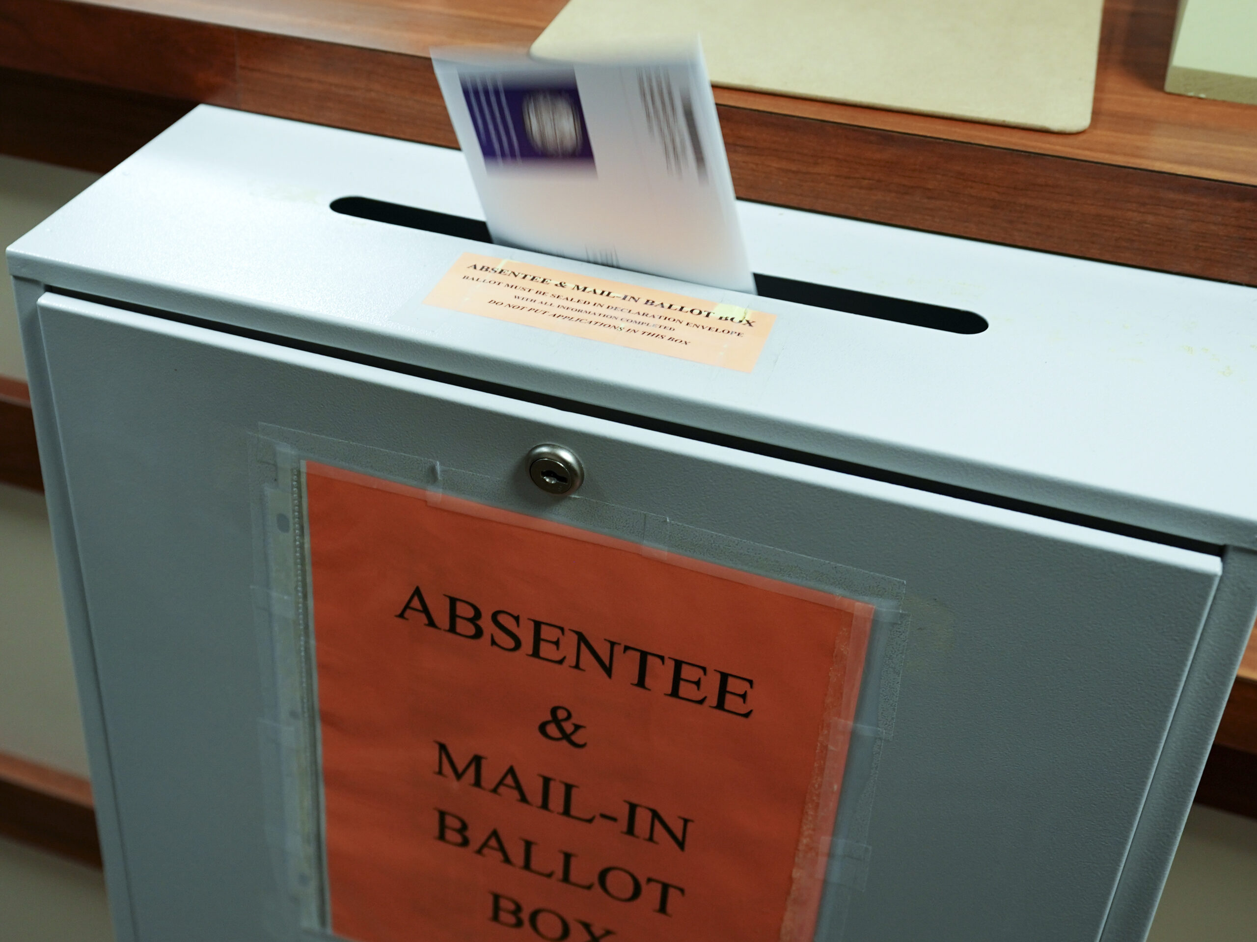 A citizen deposits a ballot into a box at the county clerk's office in Erie, Pa., on Oct. 15, 2020.