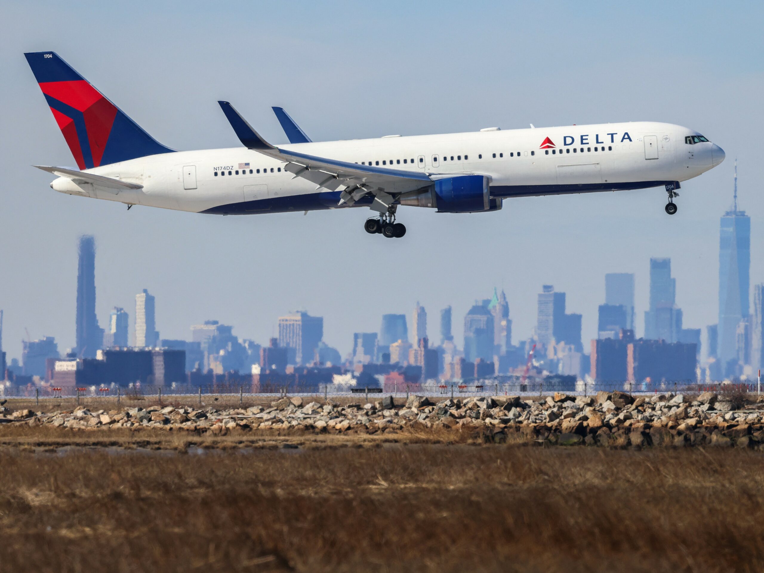 A Boeing 767 passenger aircraft of Delta Air Lines arrives from Dublin at JFK International Airport in New York as the Manhattan skyline looms in the background on Feb. 7, 2024.