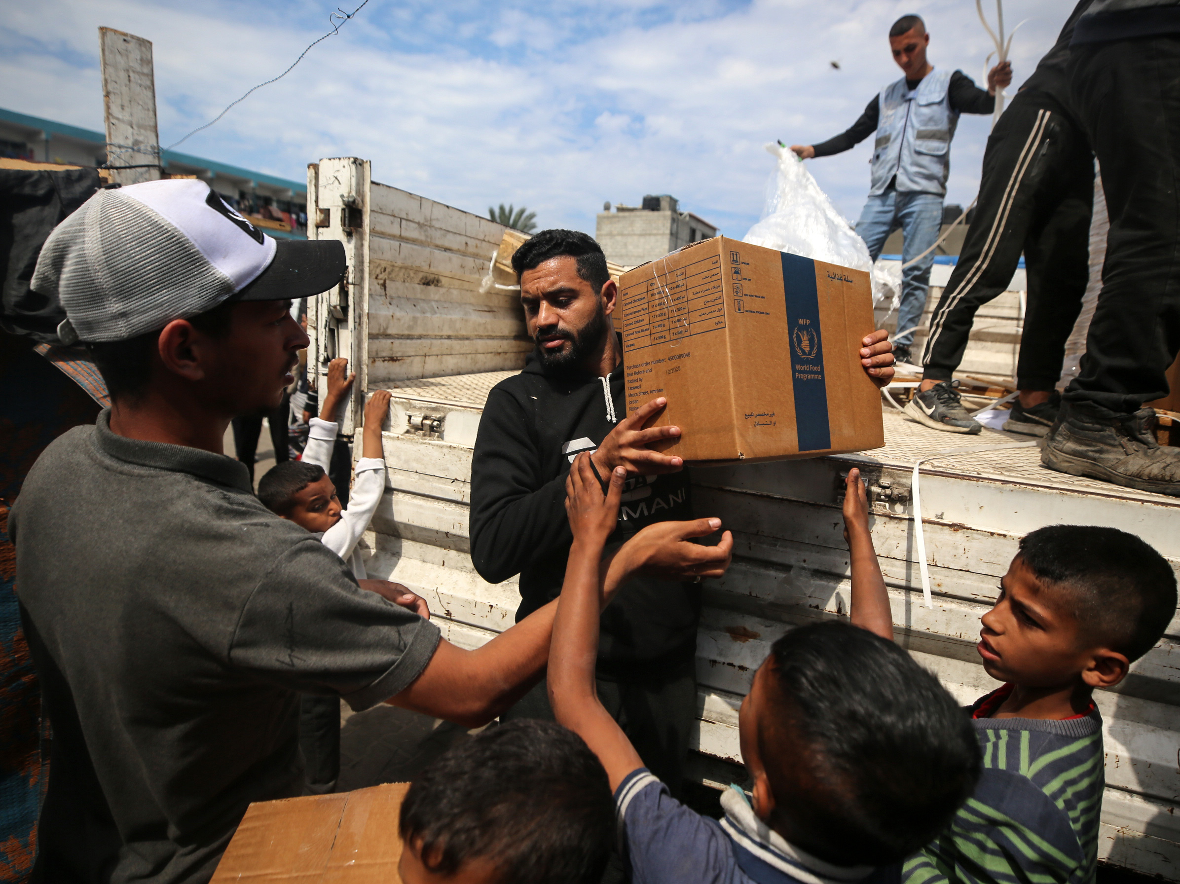 A Palestinian is carrying boxes of aid distributed before the Eid al-Fitr holiday, which marks the end of the Muslim holy fasting month of Ramadan, amid the ongoing conflict between Israel and Hamas, in Deir al-Balah, in the central Gaza Strip, on Monday.