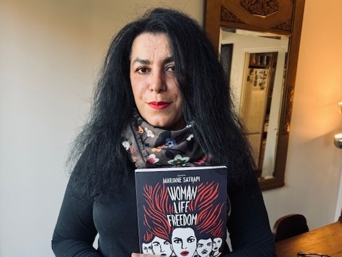Marjane Satrapi, a graphic novelist, holds her latest book Woman, Life, Freedom, in her home in Paris, France.