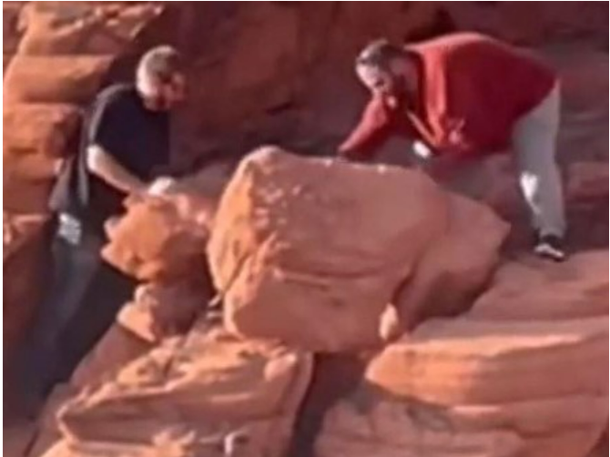 An image provided by the National Park Service shows two men who were caught on video earlier this month toppling rock formations near the Redstone Dunes Trail.
