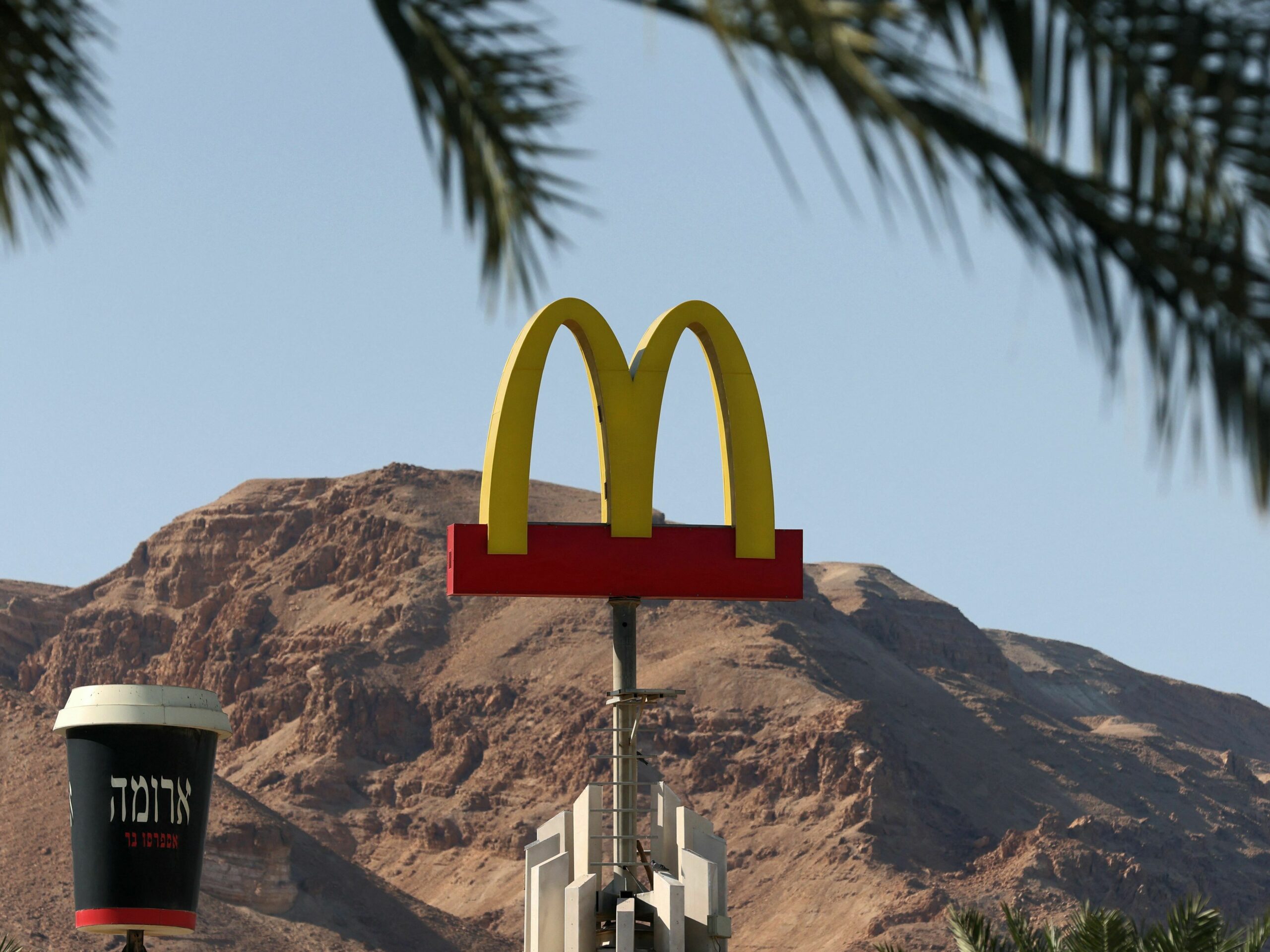 A McDonald's restaurant's iconic "golden arches" logo next to a giant coffee cup of its "Aroma" trademark in the Israeli Dead Sea resort town of Ein Bokek.
