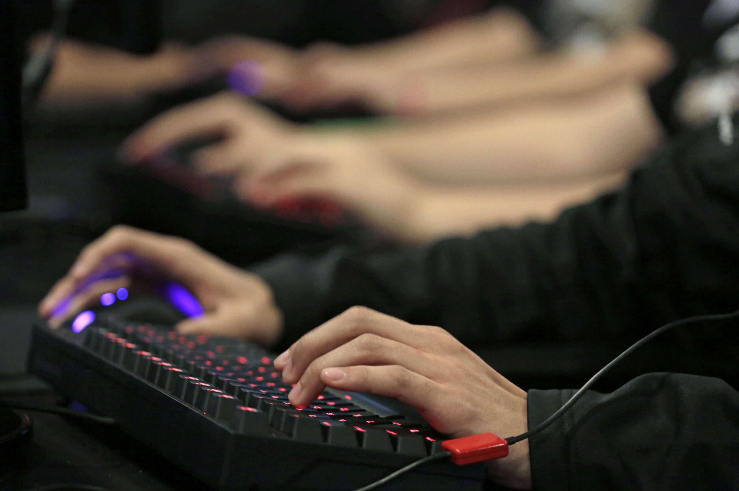 Hands are shown at a keyboard, playing a video game