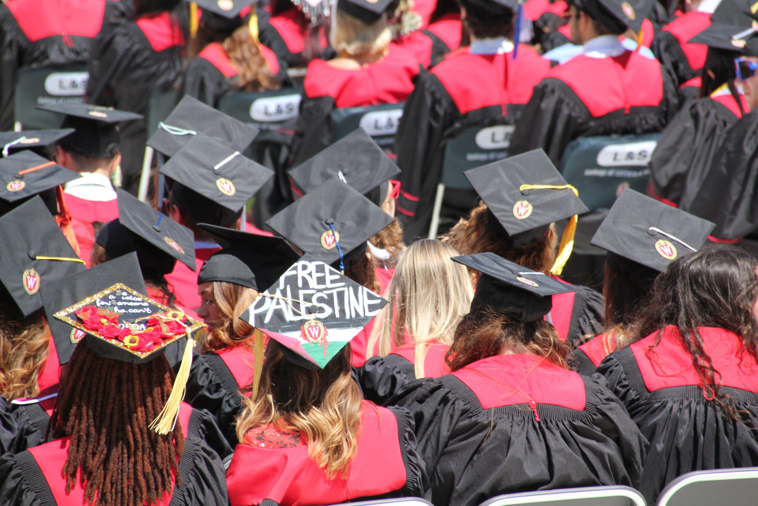 A University of Wisconsin-Madison student wears a graduation cap with the message "FREE PALESTINE" painted on top.