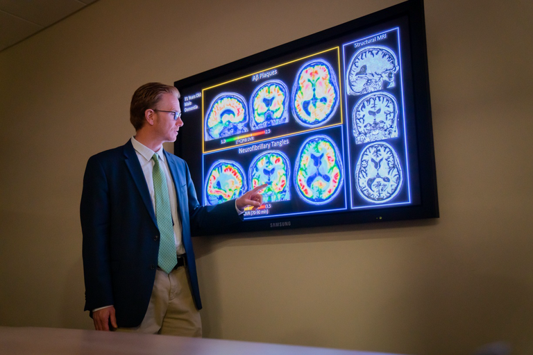 UW-Madison professor Sterling Johnson examines images from PET scans