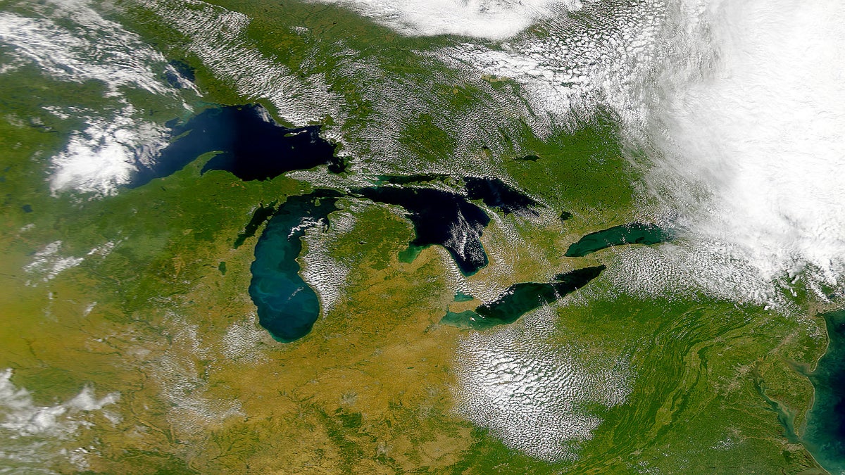 Satellite view of the Great Lakes region from 2013 surrounded by broung and green land and under partly cloudy sky. (Photo courtesy of the National Oceanic and Atmospheric Administration's Great Lakes Region)