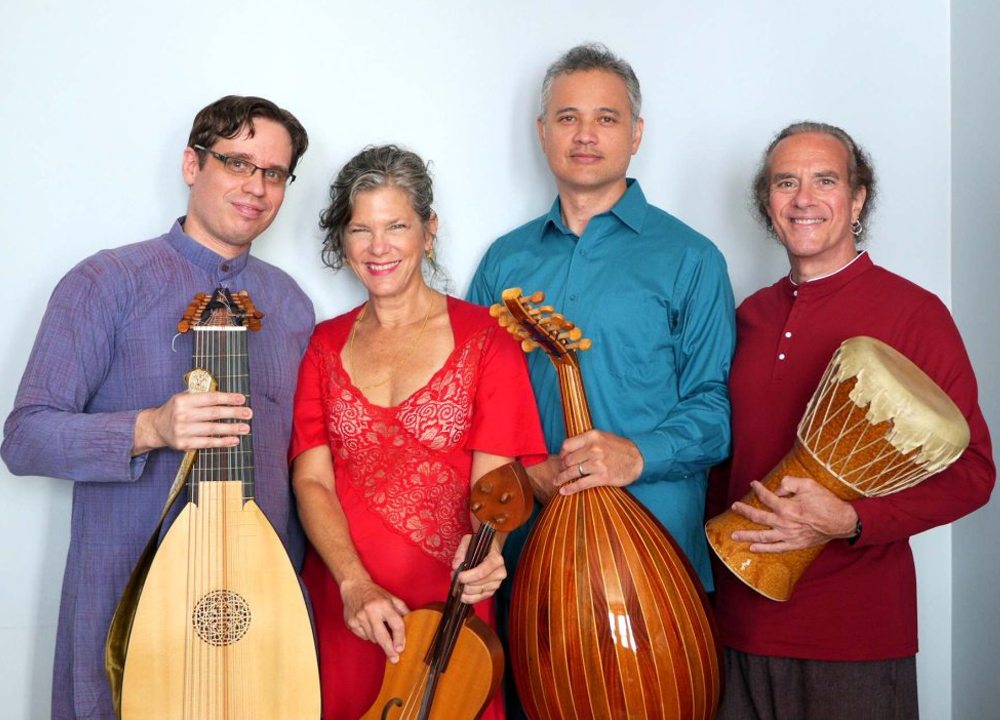 Four people stand side by side holding musical instruments: a lute, a violin, an oud, and a djembe, against a plain light-colored background.
