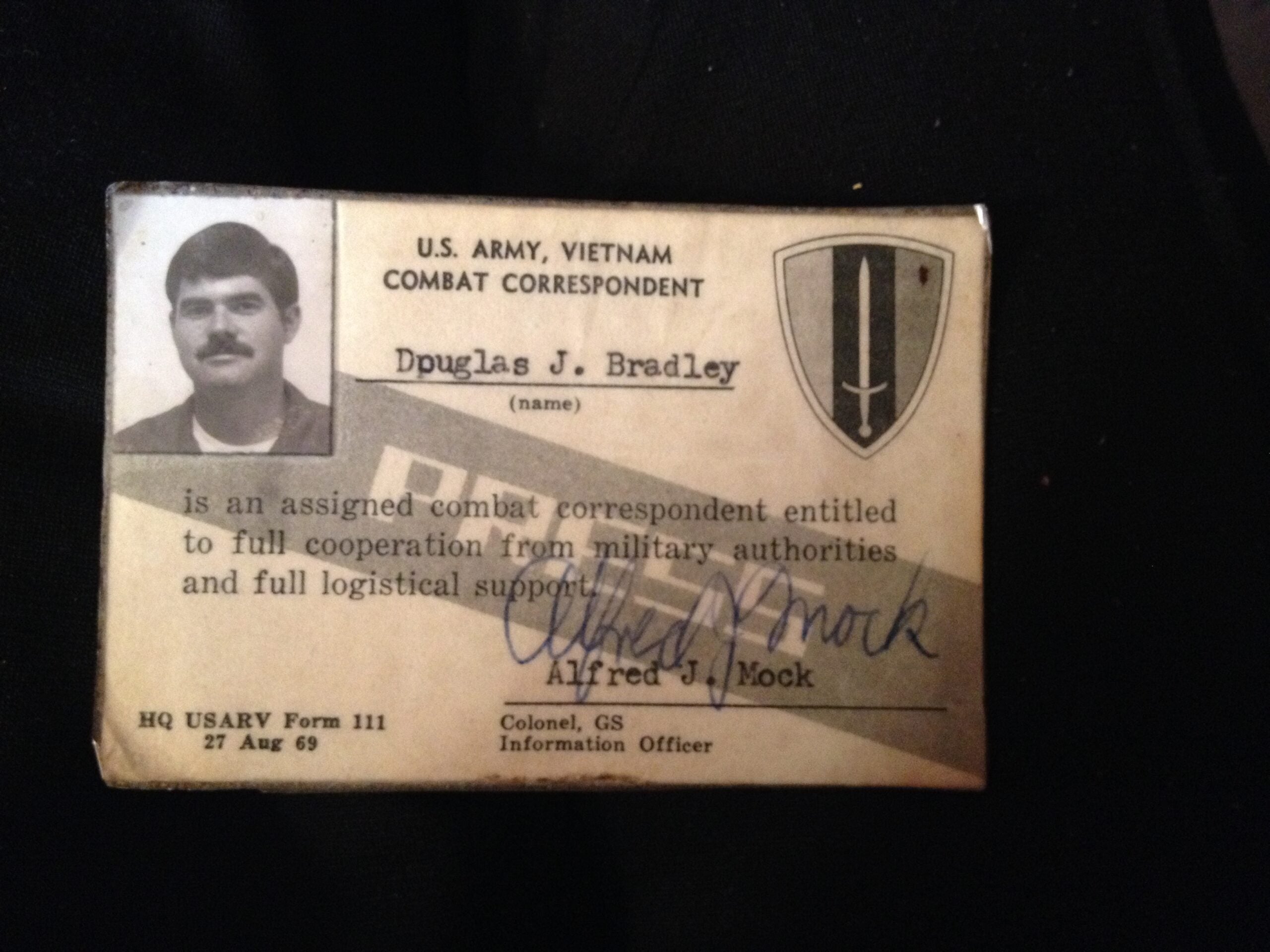 A U.S. Army, Vietnam combat correspondent ID card for Douglas J. Bradley, signed by Alfred J. Mock, Colonel, GS, dated 27 Aug 69.