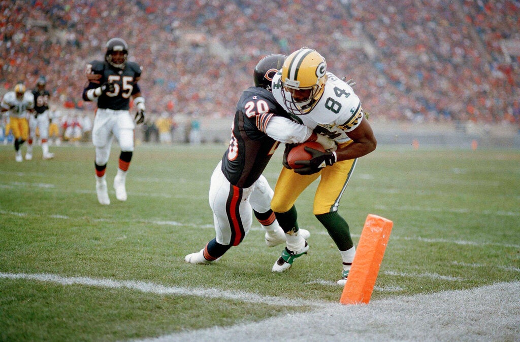 A Green Bay Packers player is tackled by a Chicago Bears defender near the end zone during a football game.