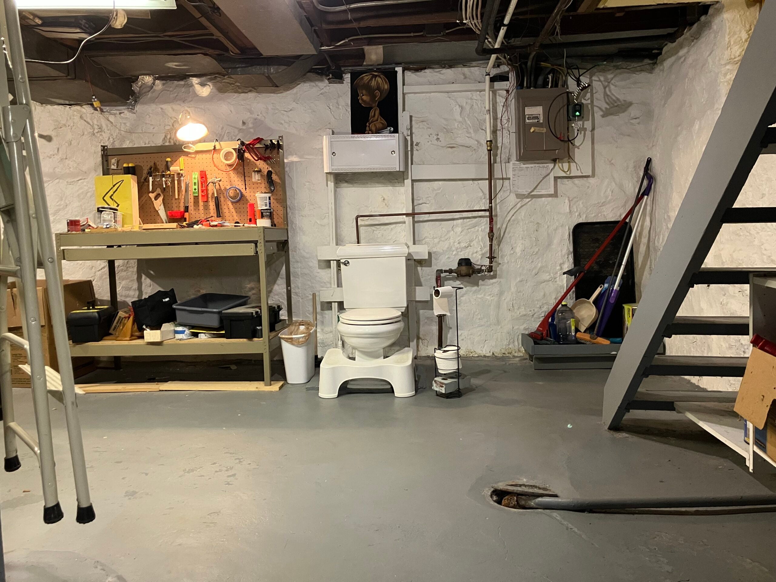 The basement toilet in Jessica Hopp's Madison, Wisc. home is fairly typical of other Midwestern basement toilets. It lacks privacy and is and surrounded a utility bench and art. <em>Photo courtesy of Jessica Hopp</em>
