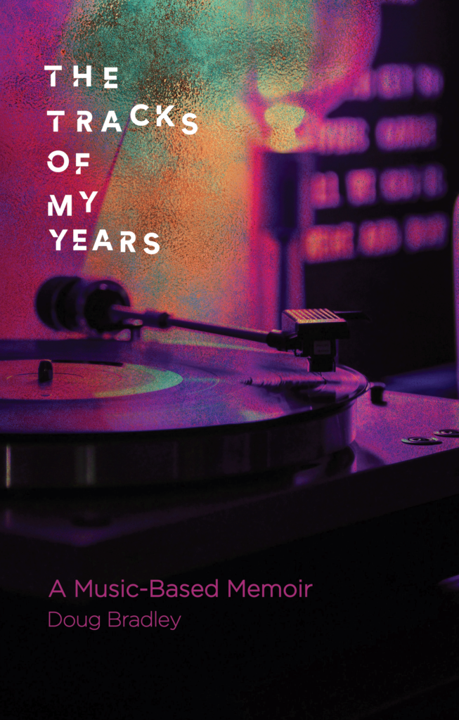 A close-up of a spinning vinyl record on a turntable, with neon purple and orange lighting. Book title: The Tracks of My Years: A Music-Based Memoir by Doug Bradley.