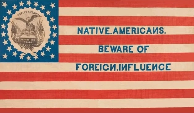 An American flag with text reading NATIVE AMERICANS. BEWARE OF FOREIGN INFLUENCE. and a seal showing an eagle with a shield surrounded by stars.