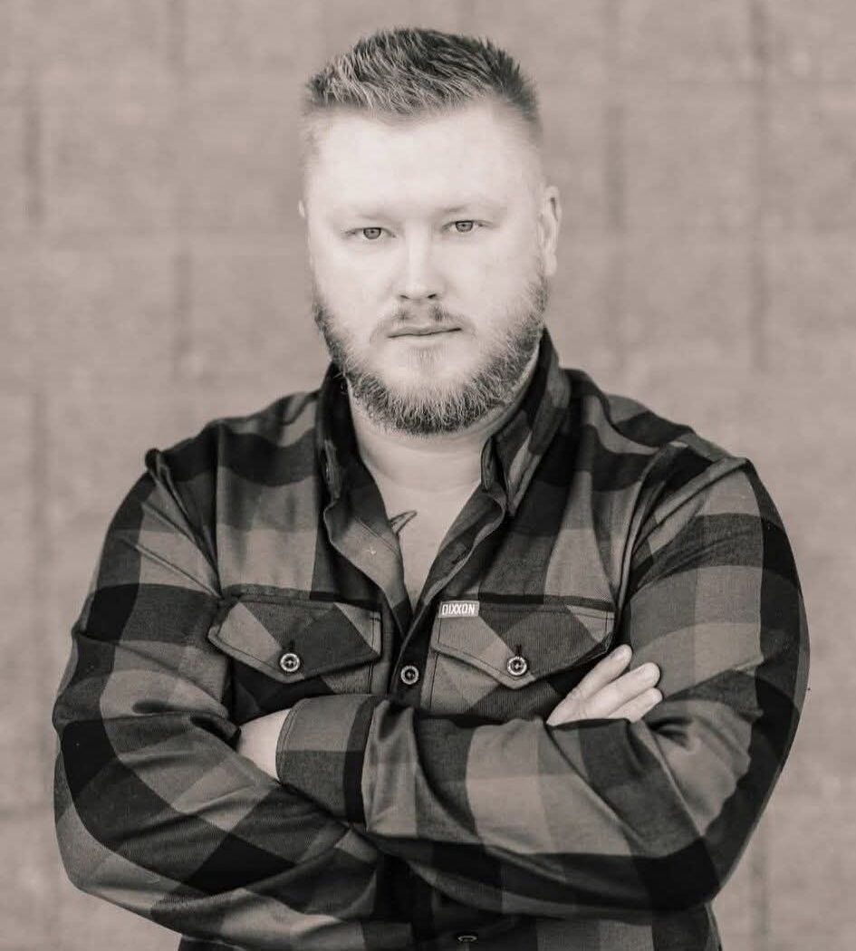 A man in a plaid shirt poses with arms crossed in a portrait. Below, two men converse in a hospital room, one seated interviewing an elderly man lying in bed.
