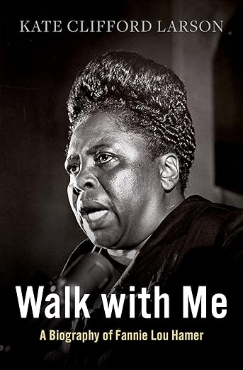 Black and white photo of Fannie Lou Hamer speaking at a microphone, featured on the cover of Walk with Me: A Biography of Fannie Lou Hamer by Kate Clifford Larson.